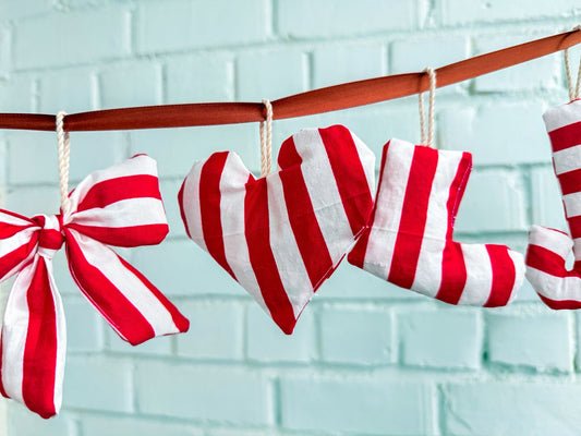 Handmade Christmas ornaments including stocking, heart and bow shapes sewn in red and white striped fabric