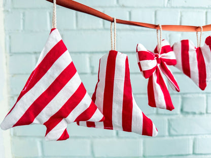 Red and white fabric Christmas ornaments hanging on a string made using a sewing pattern