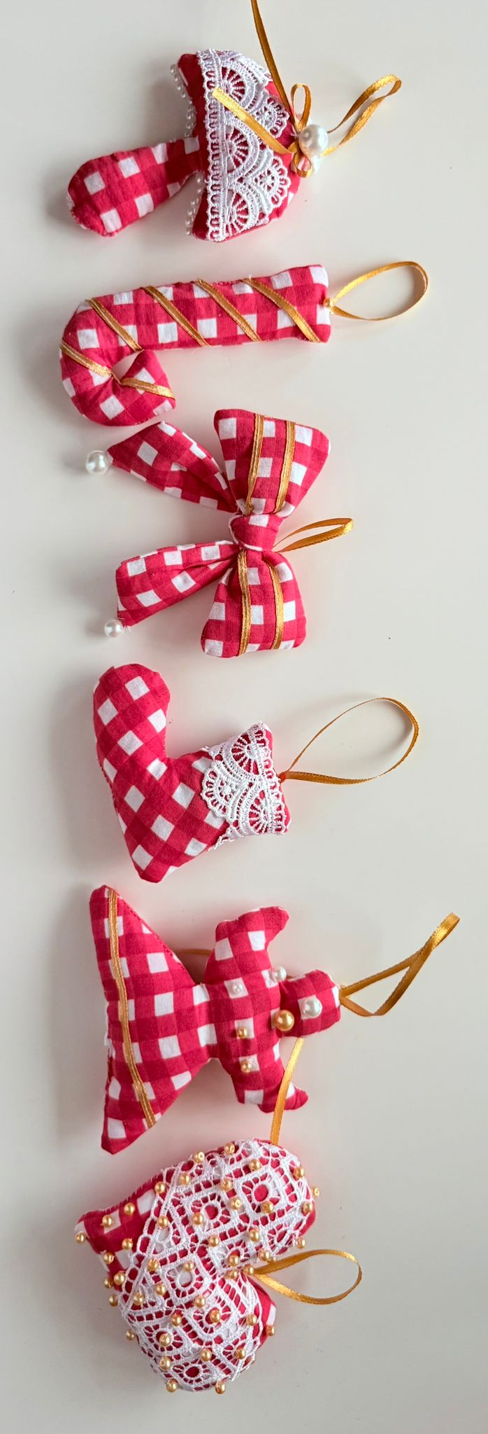 Set of red and white checkered heart-shaped ornaments on a light gray background