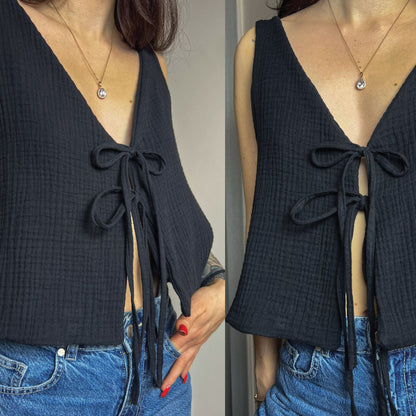 A woman wearing a dark navy textured sleeveless top with a deep V-neck and front tie closure, paired with blue jeans. The image shows a split view of the same outfit from slightly different angles.