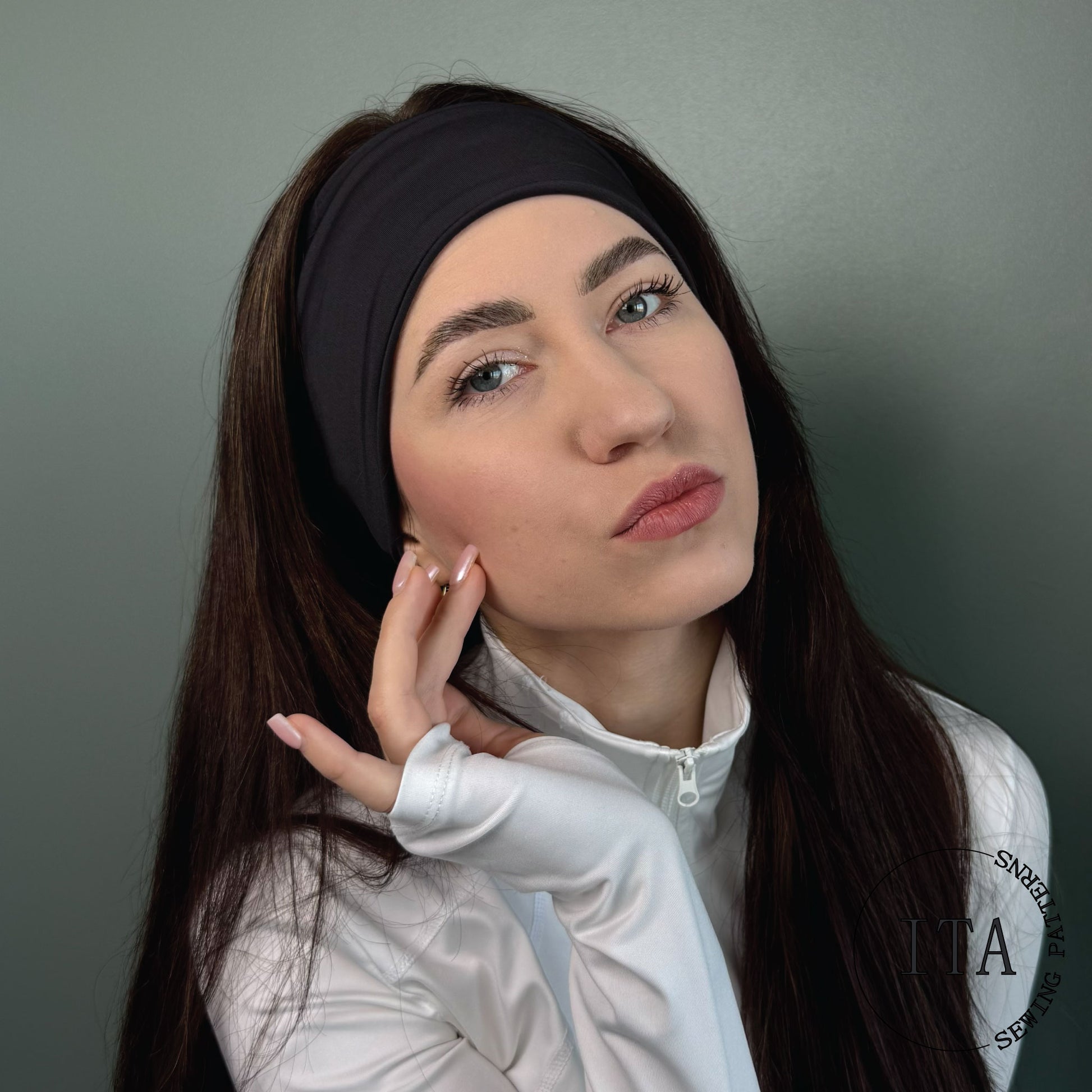 Woman wearing a black headband sewing pattern and white jacket against a gray background with ITA sewing patterns logo