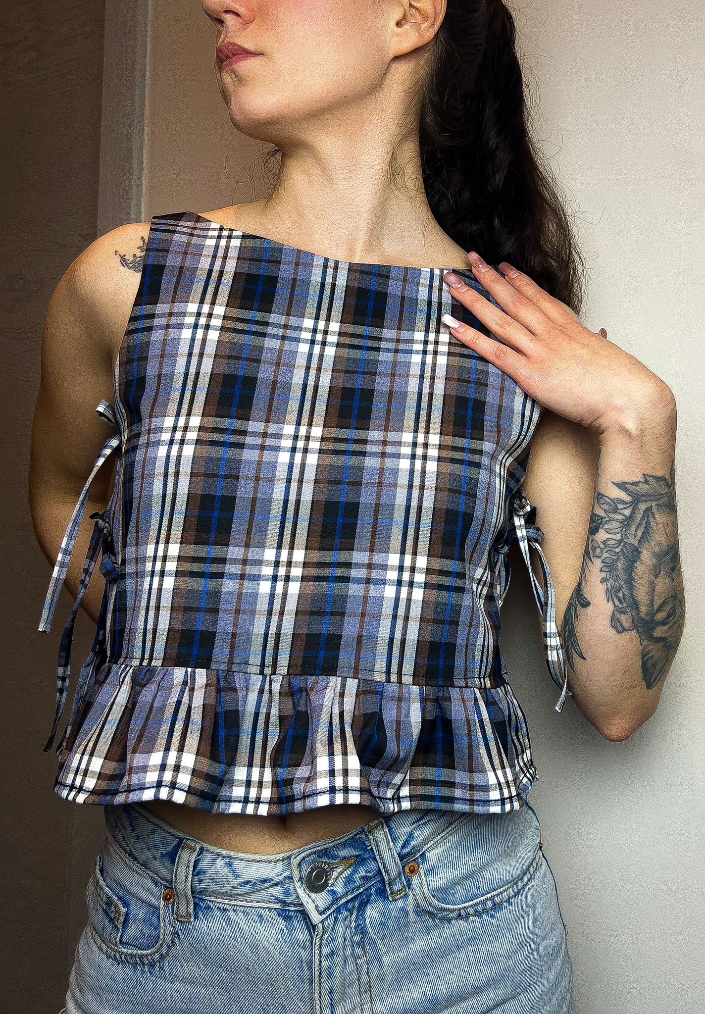 Lila ruffle tie top sewing pattern shown from the front on model with side ties and ruffle hem.