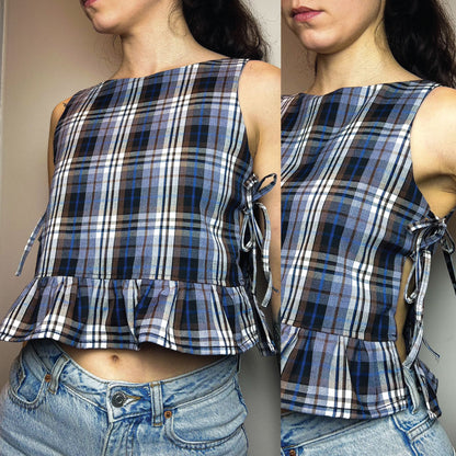 A sleeveless plaid crop top with a ruffled hem and side tie details, shown on a model wearing blue jeans. The image is a side-by-side composite showing two angles of the top against a plain indoor wall.