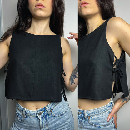 A woman modeling a black sleeveless crop top with side tie details, shown in a split front and side view against a plain indoor wall.