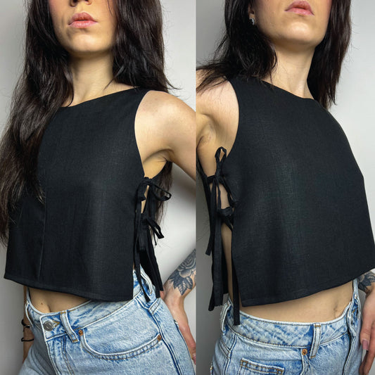 A woman modeling a black sleeveless crop top with side tie details, paired with light-wash blue jeans, shown in a split front and back view against a plain light gray background.