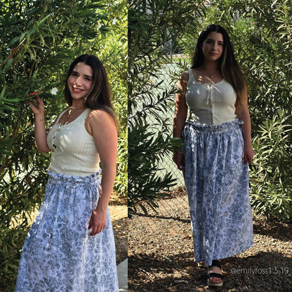 A side-by-side collage shows a woman outdoors wearing a sleeveless cream top and a long light blue floral skirt. The background consists of dense green foliage and a gravel path.