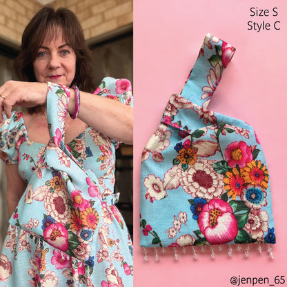 A split image showing a woman wearing a light blue floral dress on the left and a matching fabric bag with fringe on the right, labeled 'Size S Style C'. The fabric features a colorful floral print on a light blue background.