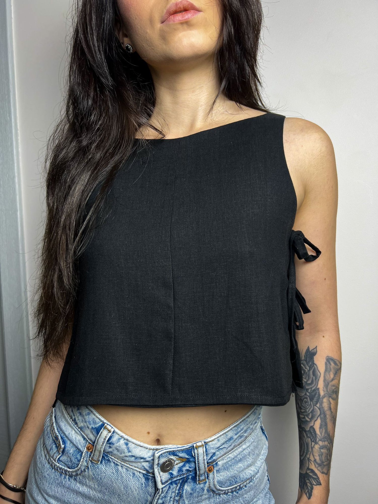 model wearing pixie side tie top made from sewing pattern with sleeveless design and adjustable side ties.