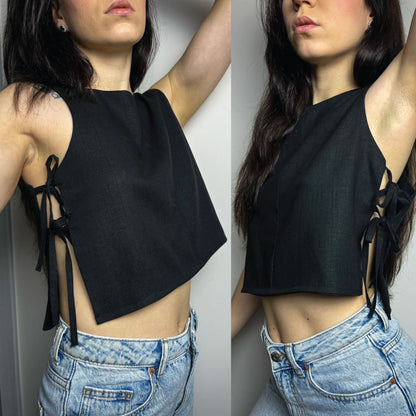 A woman modeling a black sleeveless crop top with side tie details, paired with light blue jeans, shown in a split front and back view against a plain light gray wall.