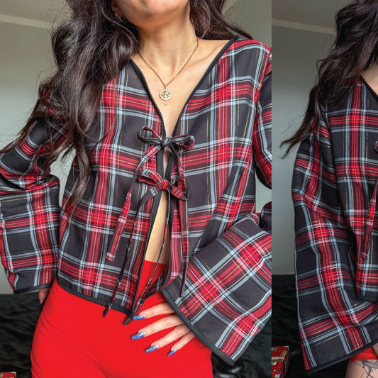 A woman wearing a red, black, and gray plaid long-sleeve tie-front top with a deep V-neck and red fitted bottoms, shown in a split close-up view.