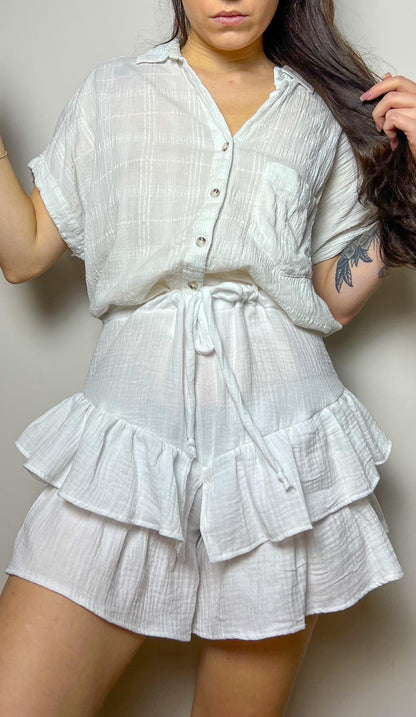 Woman wearing handmade velora shorts with ruffled hem and tie waist, showcasing the finished result of the velora shorts sewing pattern.